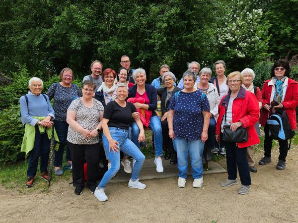 Viele fröhliche Frauen um eine Bank stehend